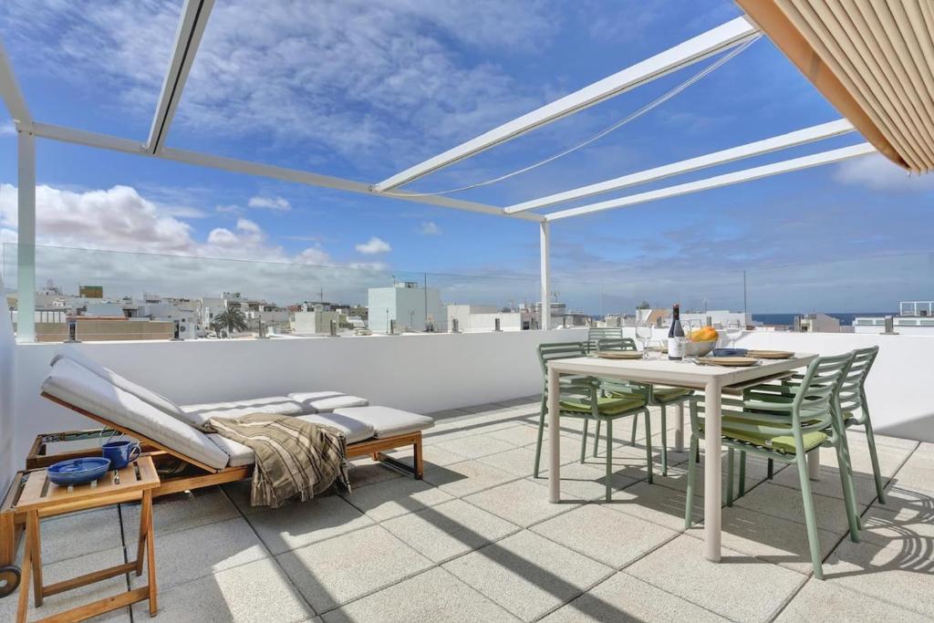 a patio with a table and chairs on a roof at Penthouse in El Cotillo in Cotillo