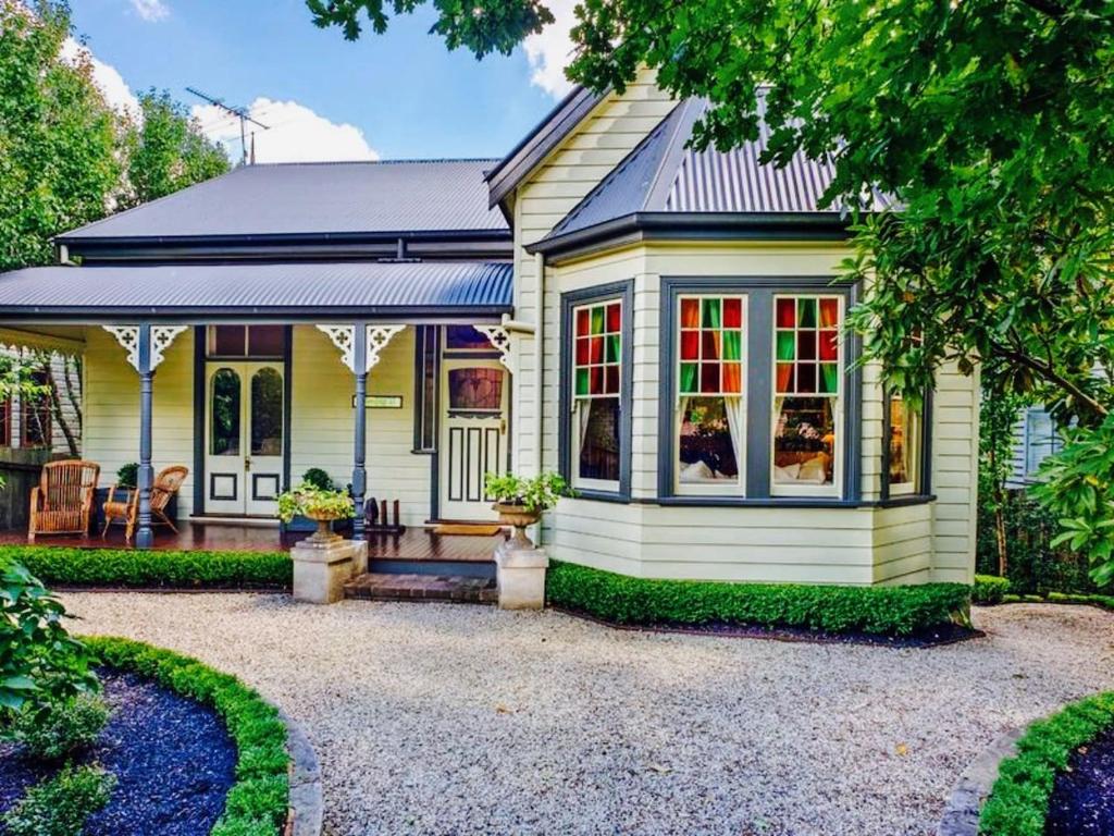 a small yellow house with a porch at Mirrabella Blue Mountains Boutique Getaway in Blackheath