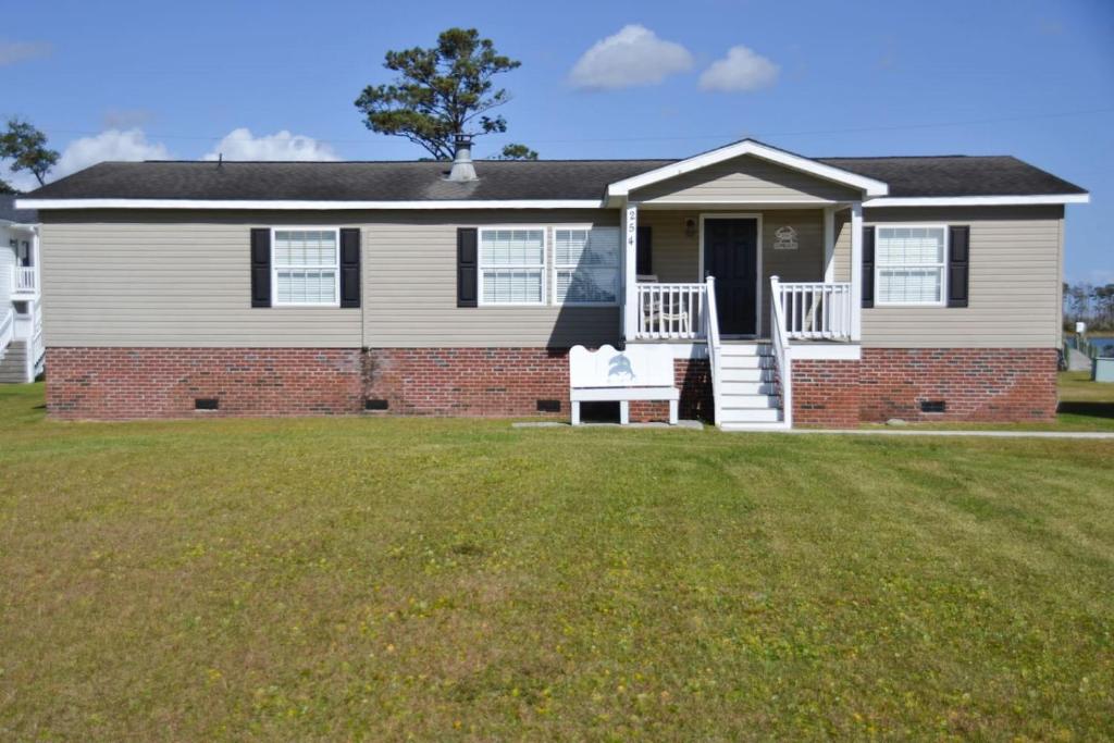 une maison avec une pelouse devant dans l'établissement 3BR Cottage Waterfront Wade Creek Fishing Boating, à Smyrna