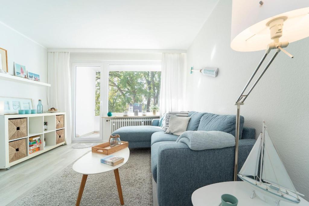 a living room with a blue couch and a table at Strandschloss Wohnung 40 in Grömitz
