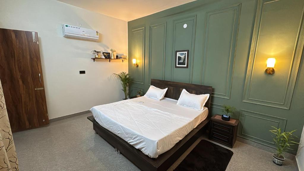 a bedroom with a bed and a green wall at Comfort stay in Beās