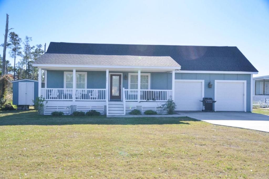 a white house with a porch and a yard at Cozy 3BR Cottage Fishing Private Dock Boating in Davis