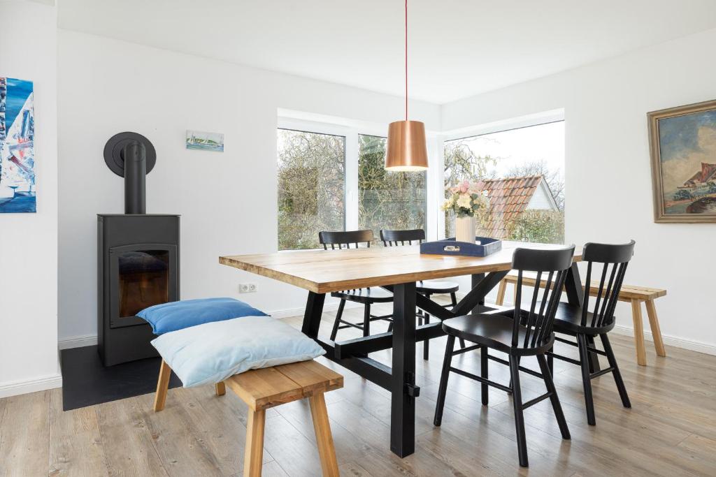 a dining room with a table and chairs and a fireplace at Kapitän Clausen in Heikendorf