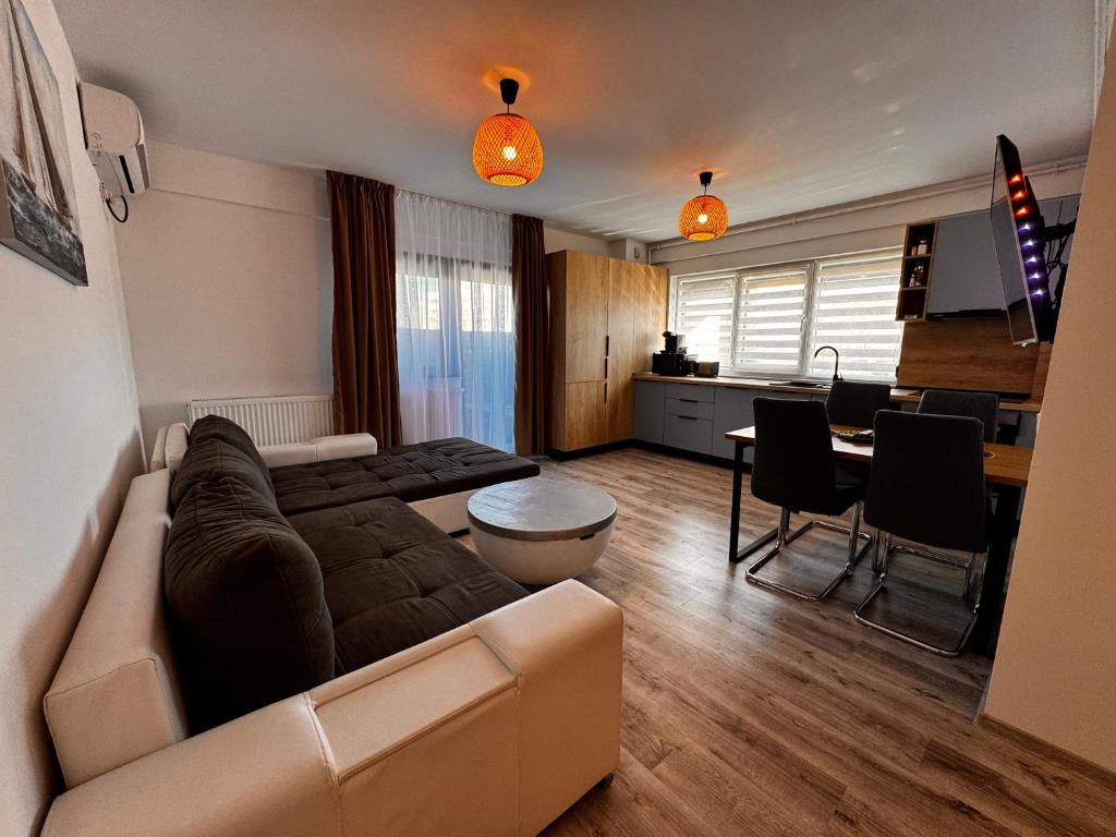 a living room with a couch and a kitchen at RoApart B2 Home Apartamente 2 și 3 camere terase spațioase vedere si parcare in Năvodari