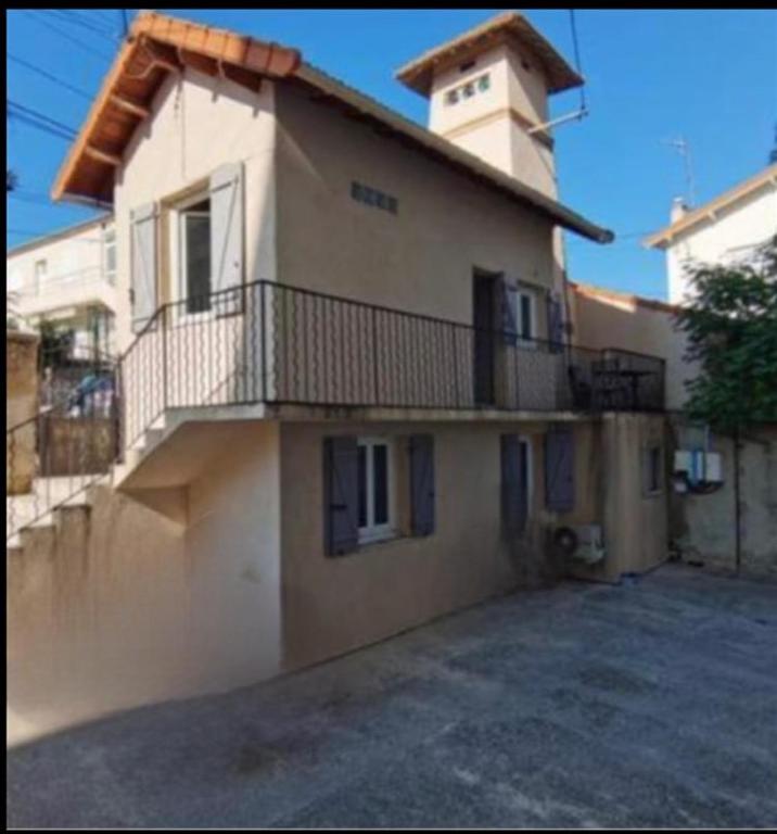 un grand bâtiment avec un balcon et une tour dans l'établissement House in Juan-les-Pins, Antibes, à Antibes