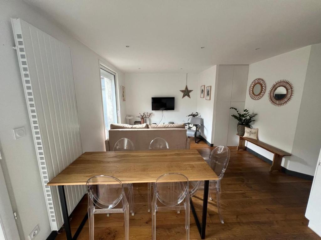 une salle à manger avec une table et des chaises en bois dans l'établissement Le cocon citadin atypique et son patio, à Tours