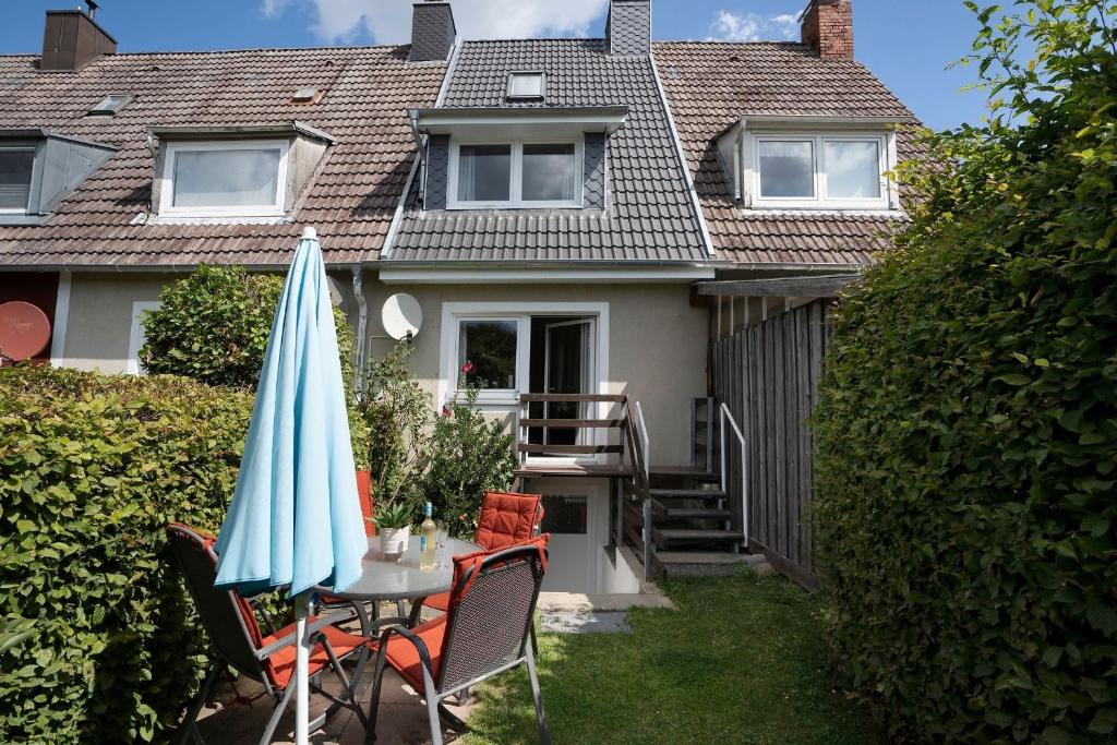 a table with an umbrella in front of a house at Möwenschrei in Dahme
