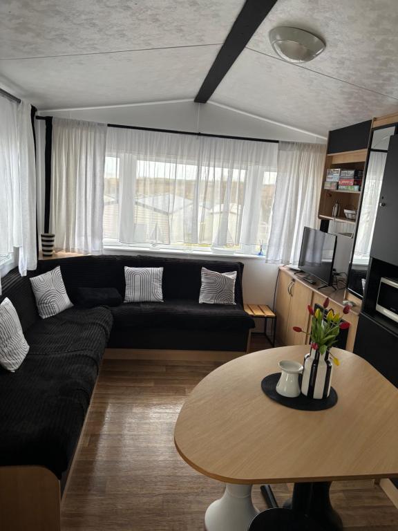 a living room with a black couch and a table at Owl10 in Tunstall