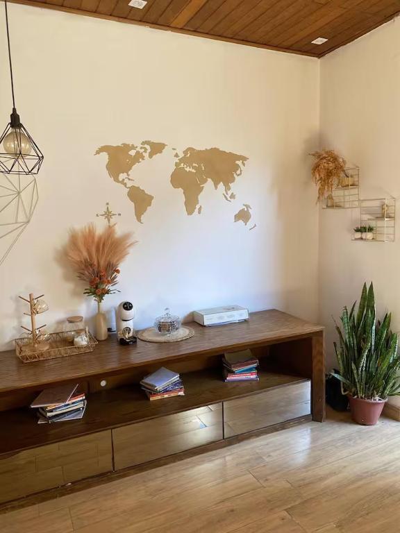 a room with a wooden table with a world map on the wall at Hostel Amor por SP - BRÁS in São Paulo