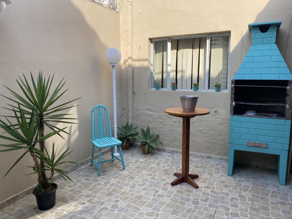 a patio with a blue chair and a table at Hostel Amor por SP - BRÁS in Sao Paulo