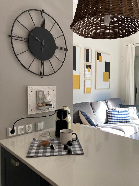 a kitchen with a large clock and a living room at APARTAMENTO CALA-NIU in Alcossebre