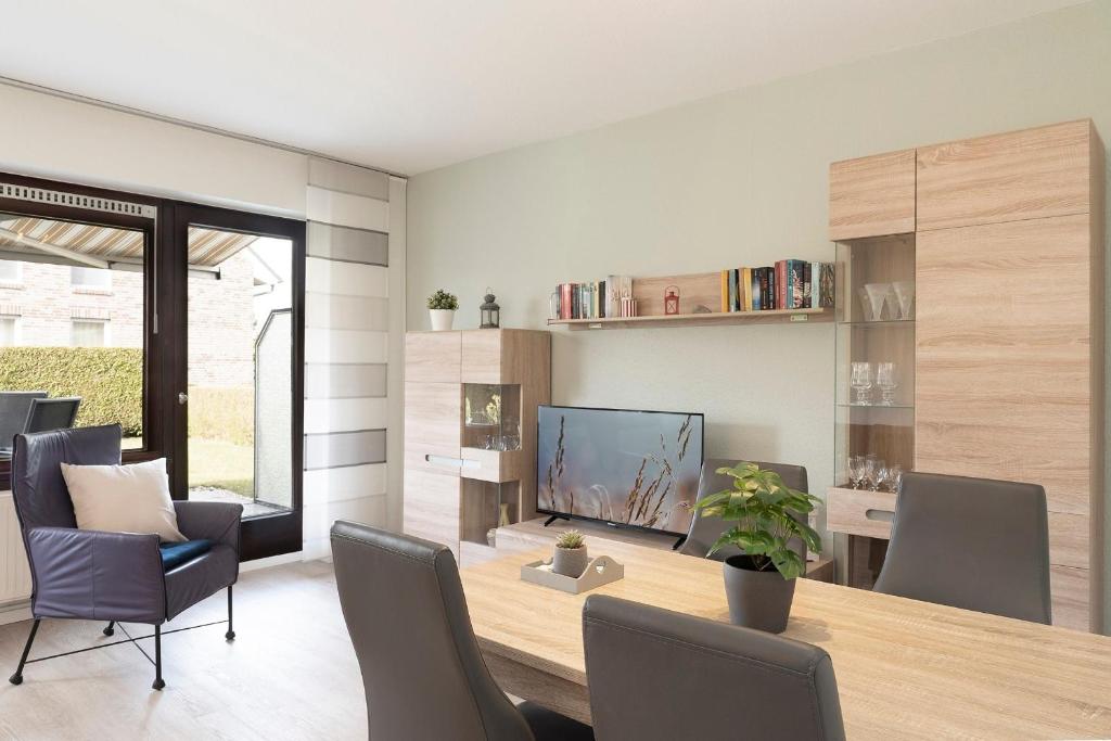 a dining room with a table and chairs and a television at Seestern in Grömitz