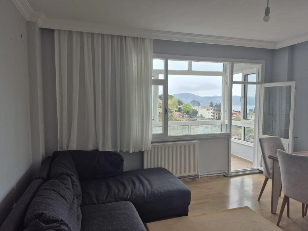 a living room with a couch and a large window at Bosphorus view apartment Sarıyer in Sarıyer
