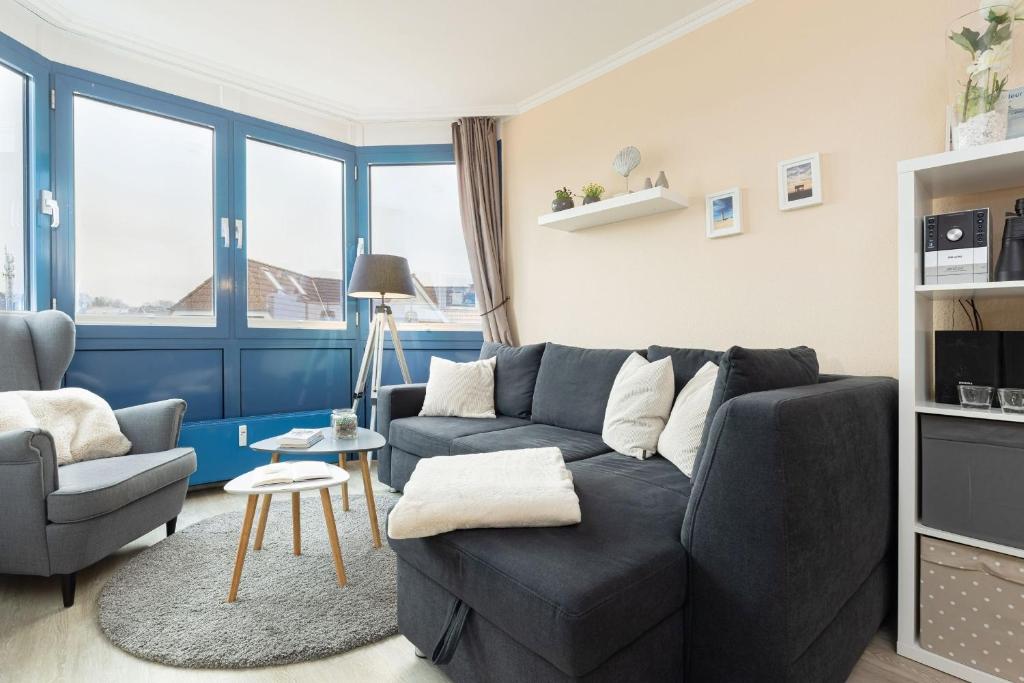 a living room with a couch and a chair at Haus Panorama Laboe Nr 21 in Laboe