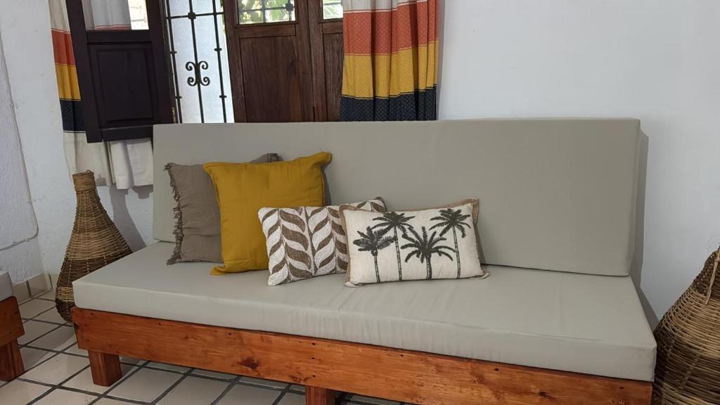 un banc blanc avec des coussins dessus dans une pièce dans l'établissement casa vacacional, à Puerto Escondido