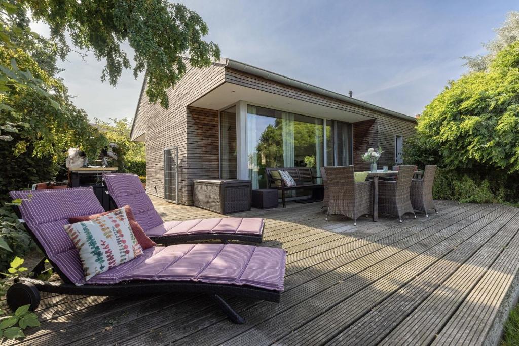a wooden deck with purple lounge chairs on it at Nienhagen in Nienhagen