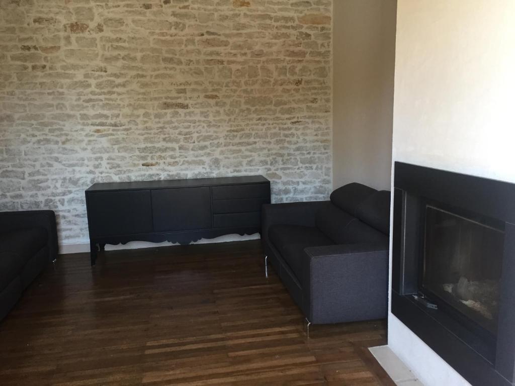 un salon avec un canapé et une cheminée dans l'établissement Maison de la mare aux rainettes Location vacances standing au cœur du marais poitevin - 3 chambres - 6 personnes, à La Celle-sous-Gouzon