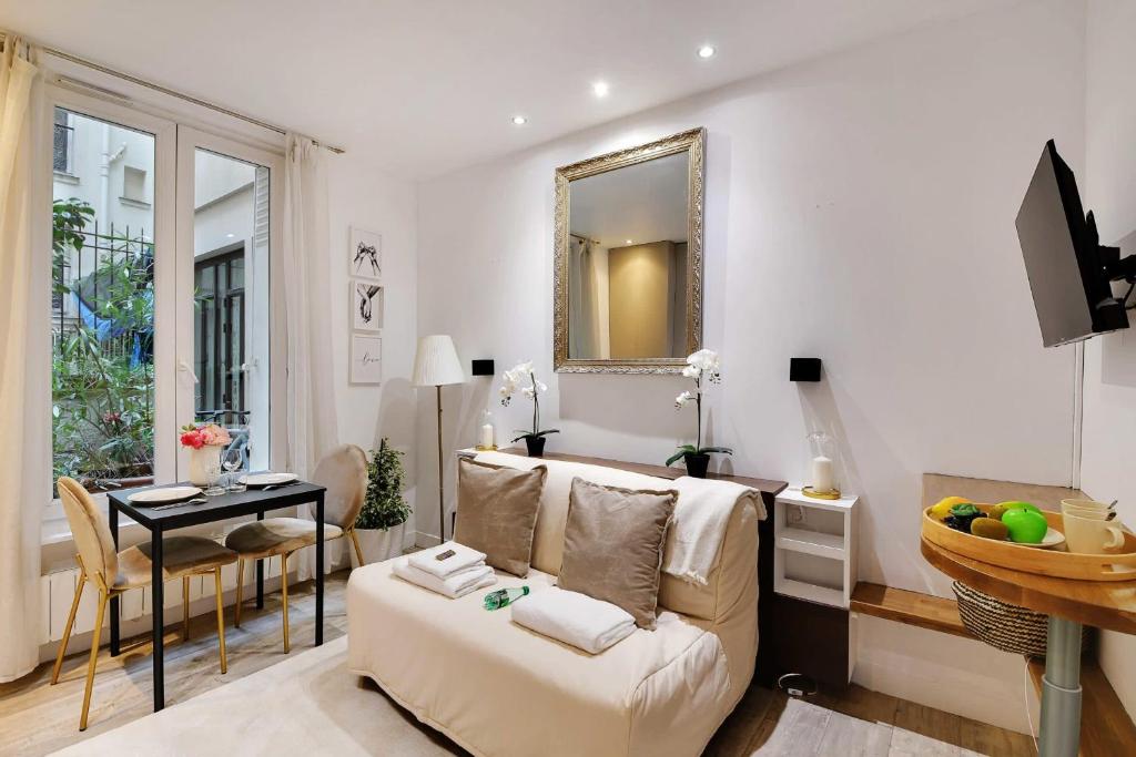 un salon avec un canapé et une table dans l'établissement Flexliving - studio - Montreuil, à Paris