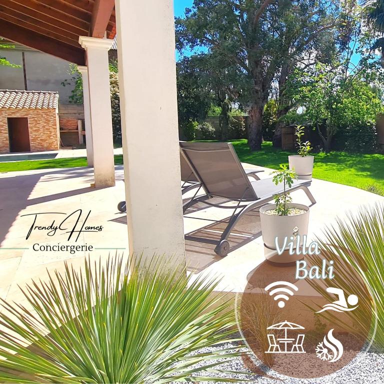 un patio avec une chaise, une table et des plantes dans l'établissement Villa Bali, à Saint-Just