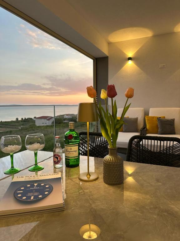 a table with two wine glasses and a vase with flowers at SeaSide Haven in Split