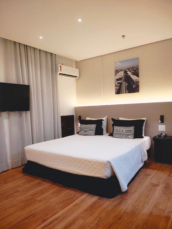 Hotel Transamerica Executive Chácara Santo Antônio, a bedroom with a large bed and a television at Transamerica Executive Chácara Santo Antônio in São Paulo