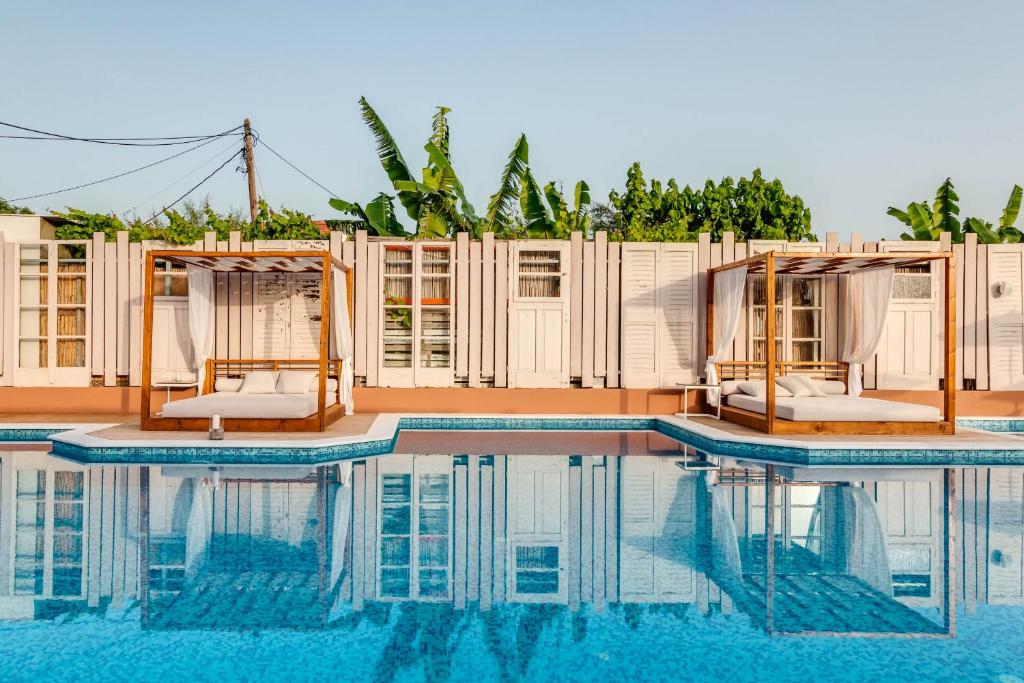 basen z 2 leżakami i dom w obiekcie Armeno Resort w mieście Marathias