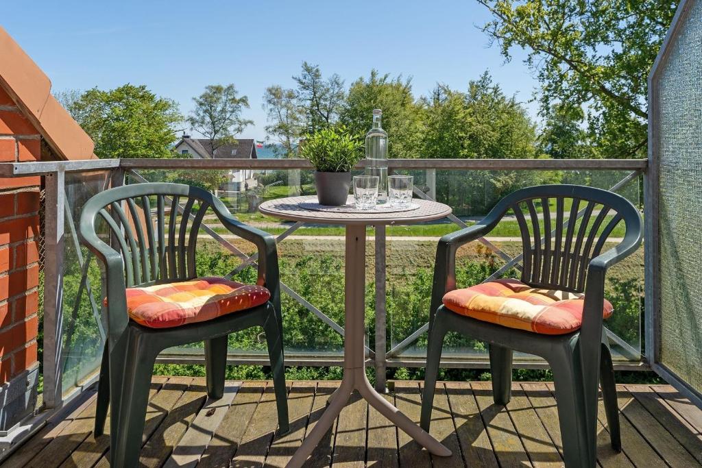 a patio table and two chairs on a balcony at Kaiserhof 42-44 Meereskrabbe in Kellenhusen