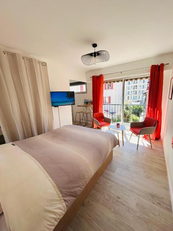 - une chambre avec un grand lit et des rideaux rouges dans l'établissement Riviera Sun, à Nice