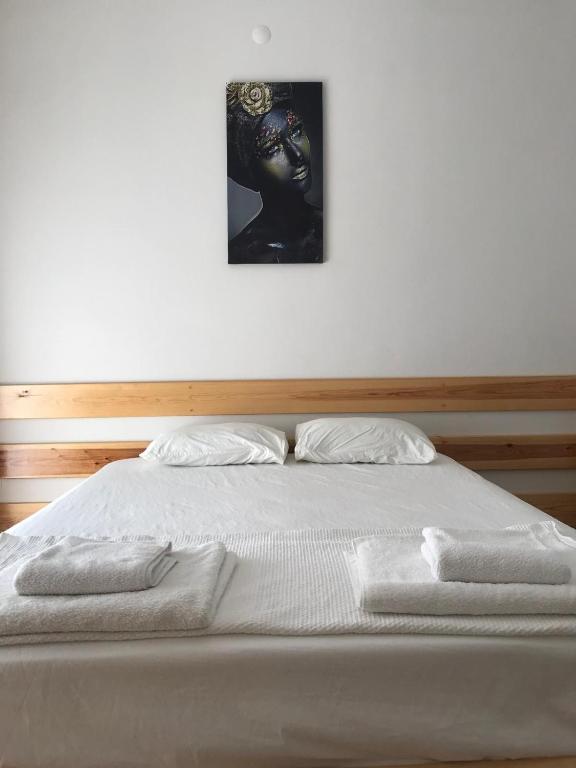 a white bed with a picture on the wall at GREEN HiLL DEFNE APART in Kaş