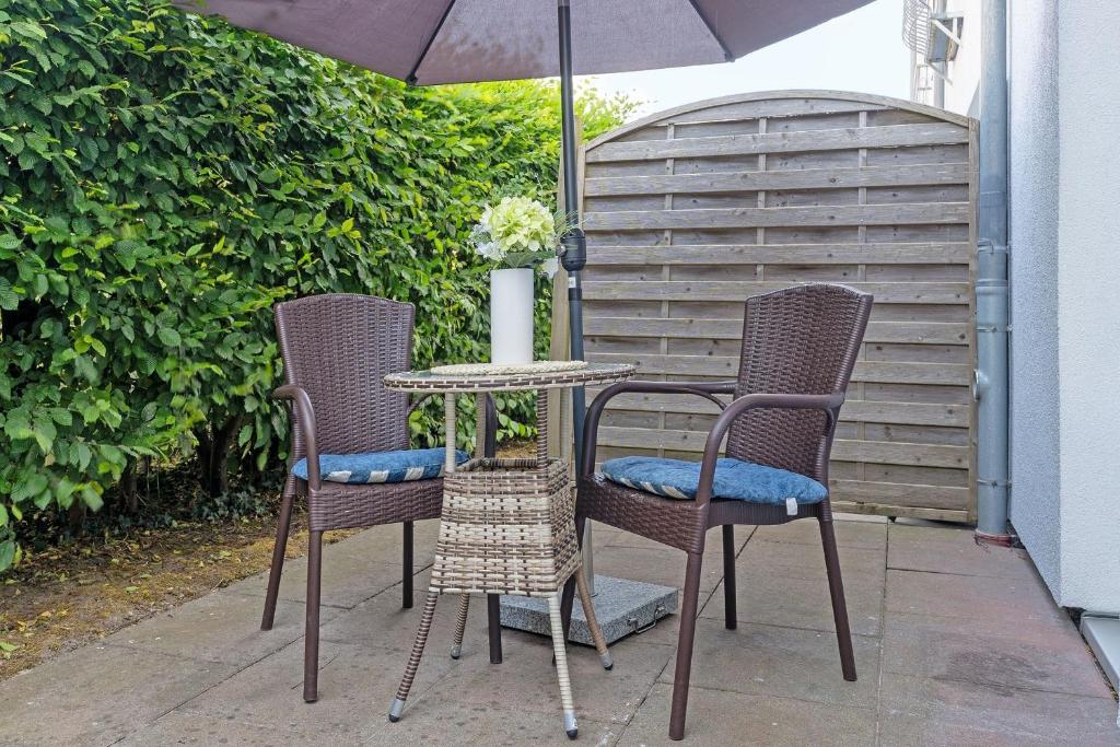 two chairs and a table with an umbrella on a patio at Seepferdchen Bargen in Hansaland
