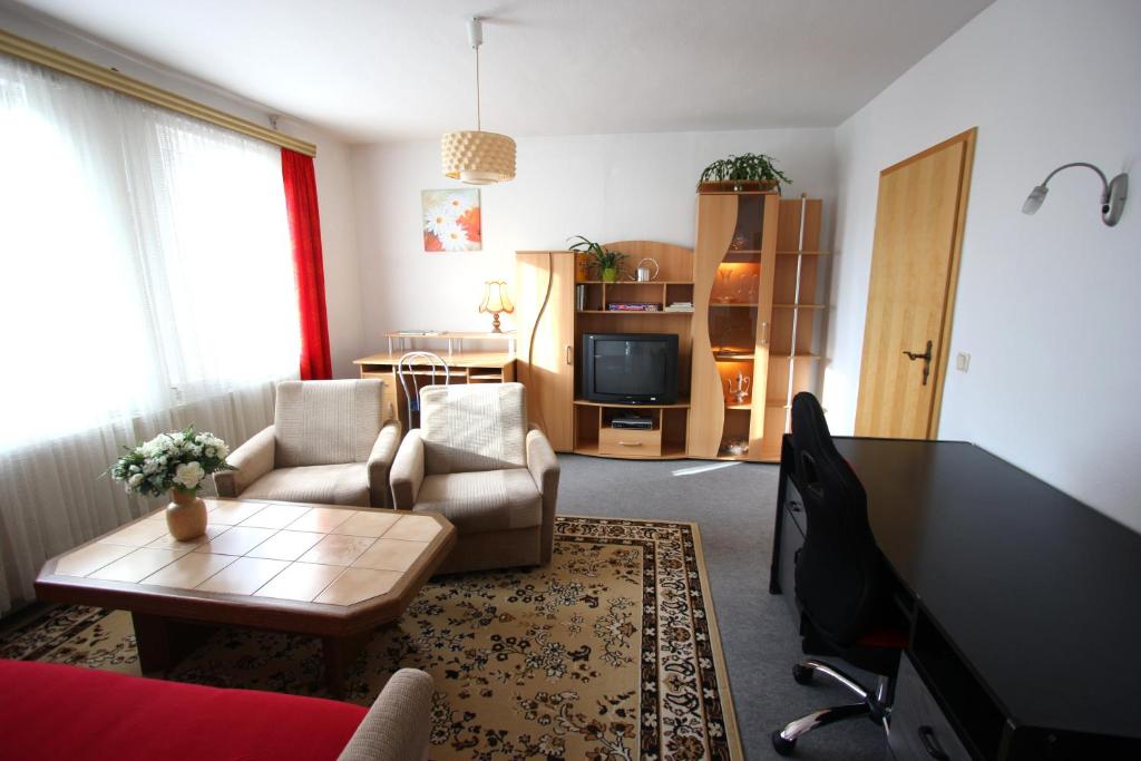 ein Wohnzimmer mit einem Sofa und einem Tisch in der Unterkunft Karin's behagliche Ferienwohnung in Benshausen