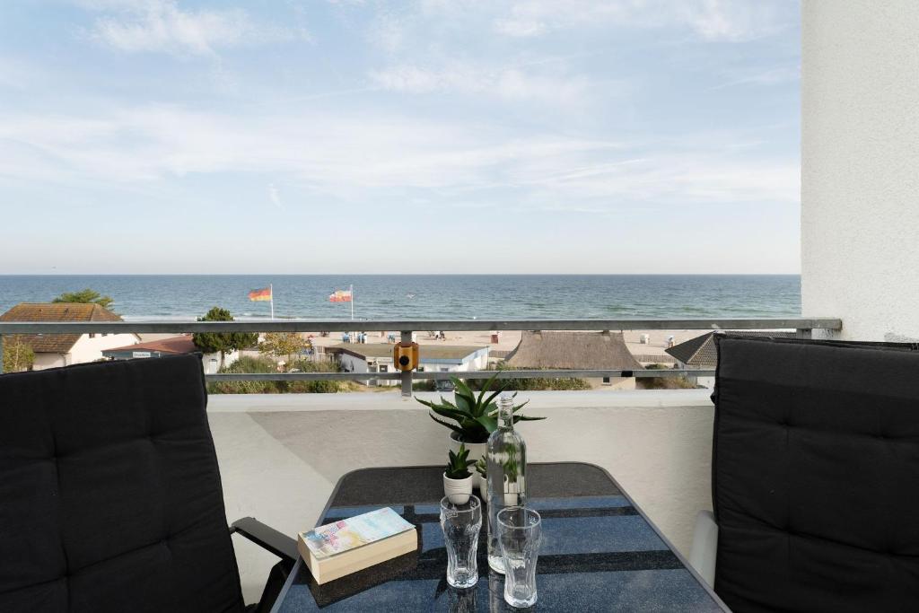 ein Tisch und Stühle mit Blick auf das Meer in der Unterkunft Strandhotel Dahme Schwalbennest Dahme in Dahme