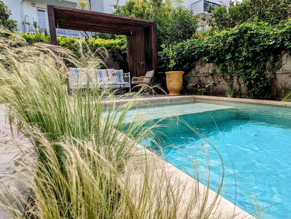 une piscine avec deux chaises et un abri en bois dans l'établissement La Villa Montcalm, à Montpellier