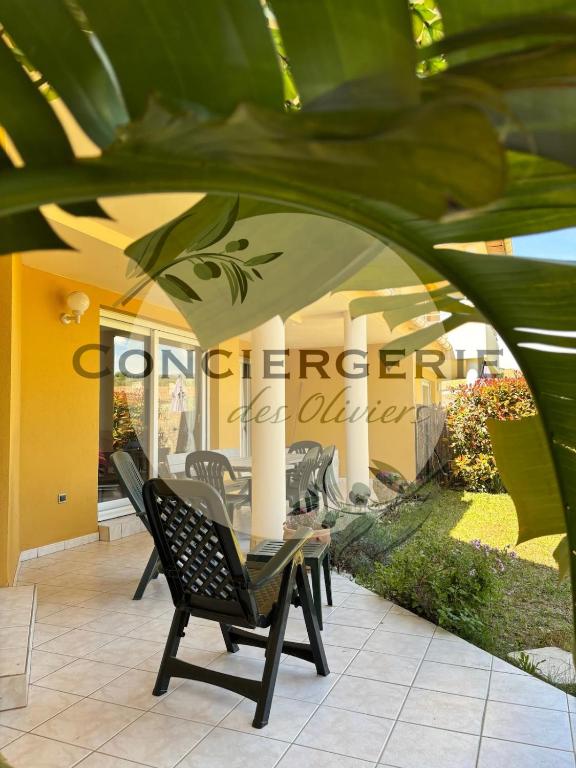 un patio avec une table et des chaises sous un parasol dans l'établissement Duplex La Favière Bormes-les-Mimosas, à Bormes-les-Mimosas