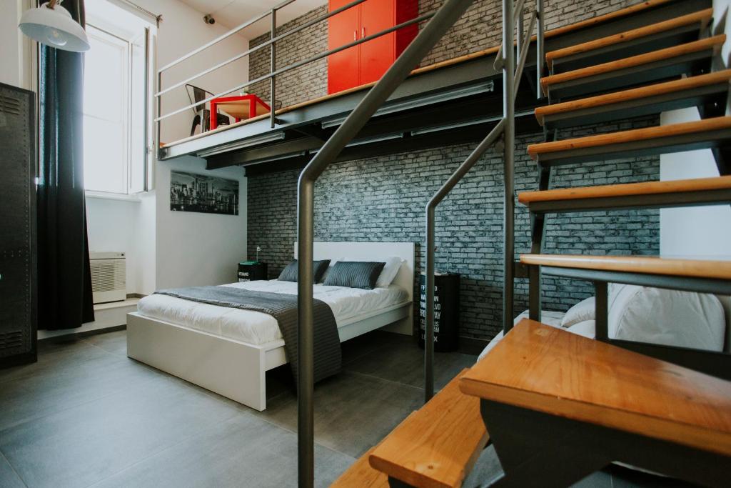 een slaapkamer met een stapelbed en een bakstenen muur bij Loft 291 in Matera