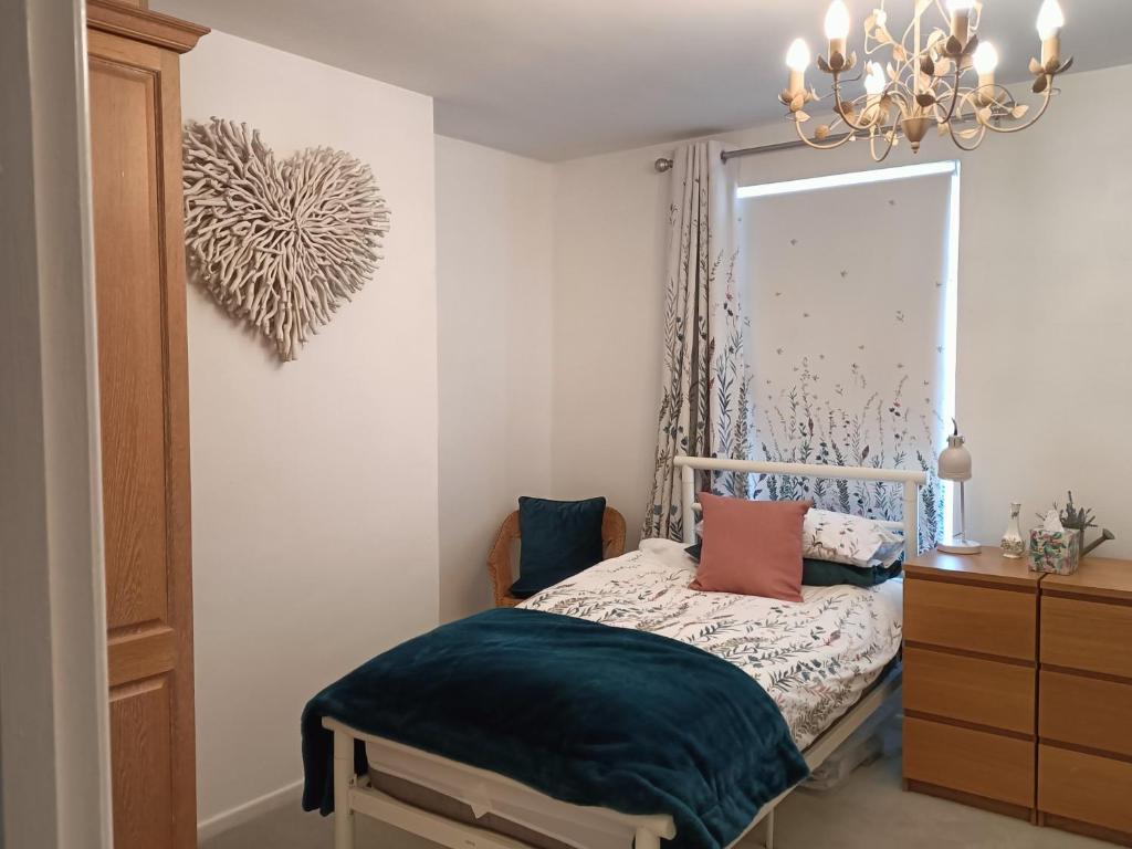 - une chambre avec un lit avec un miroir et une commode dans l'établissement Mill cottage, à Carrickfergus