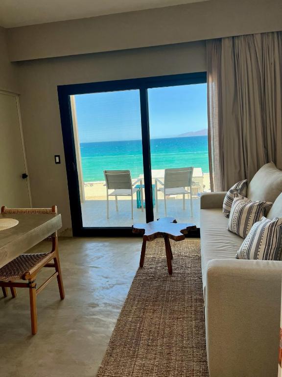 a living room with a couch and a view of the ocean at Dpto frente a la playa Beach Front Bahia turquesa in La Ventana