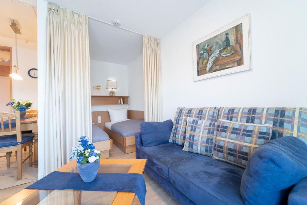 a living room with a blue couch and a table at Hamburger Straße 3- Wohnung 5 in Grömitz