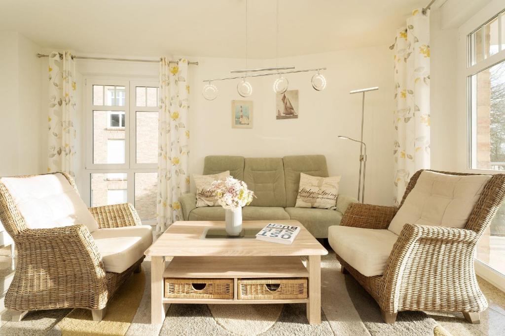 un salon avec un canapé et deux chaises dans l'établissement Bürgermeister-Fox 42a Meer-Blick, à Neue Tiefe Fehmarn