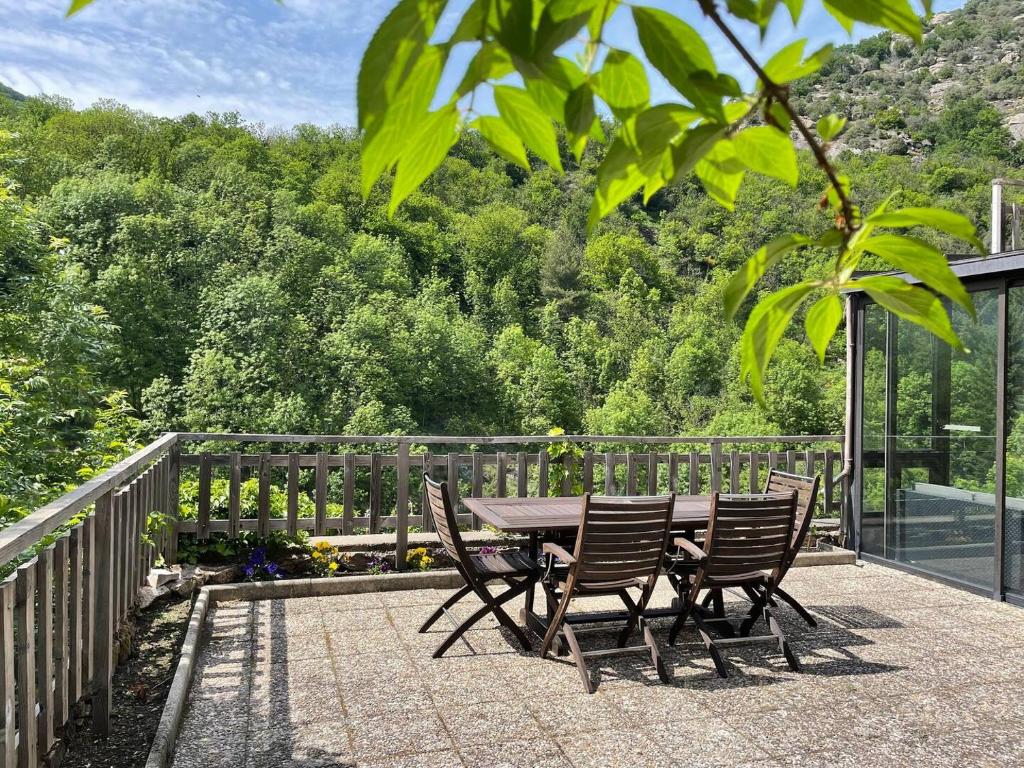 une table et des chaises en bois assises sur une terrasse dans l'établissement Maison typique ardéchoise et sa rivière privée, à La Celle-sous-Gouzon