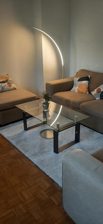 a living room with two couches and a glass table at Cosy -confort appartment in Antwerp