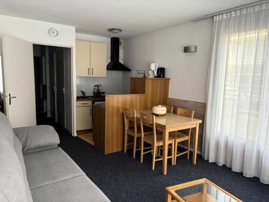 Il comprend un salon et une cuisine avec une table et un canapé. dans l'établissement LE CHALET - Piscine 15 - Studio pour 4 Personnes MAE-8794, à Gourette
