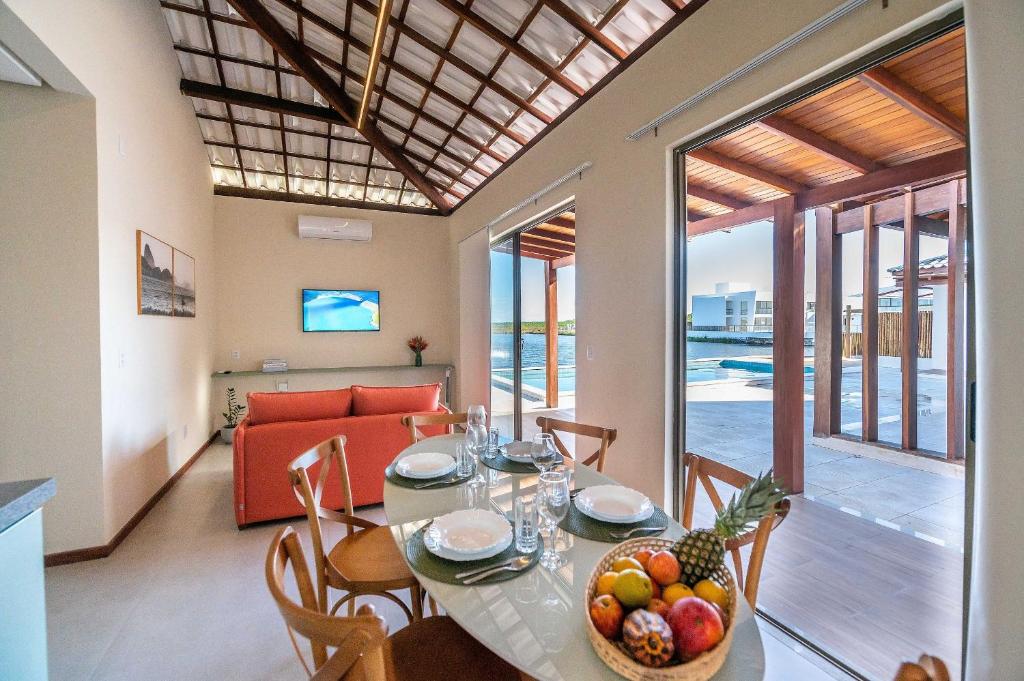 a dining room with a table with a bowl of fruit at Casa Pé no Lago - Descanso em Família na Praia de Barra Grande! in Barra Grande