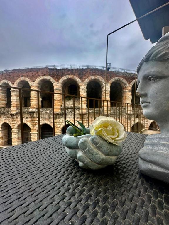 a statue of a face with a flower in a bowl at Le STELLE SULL'ARENA in Verona