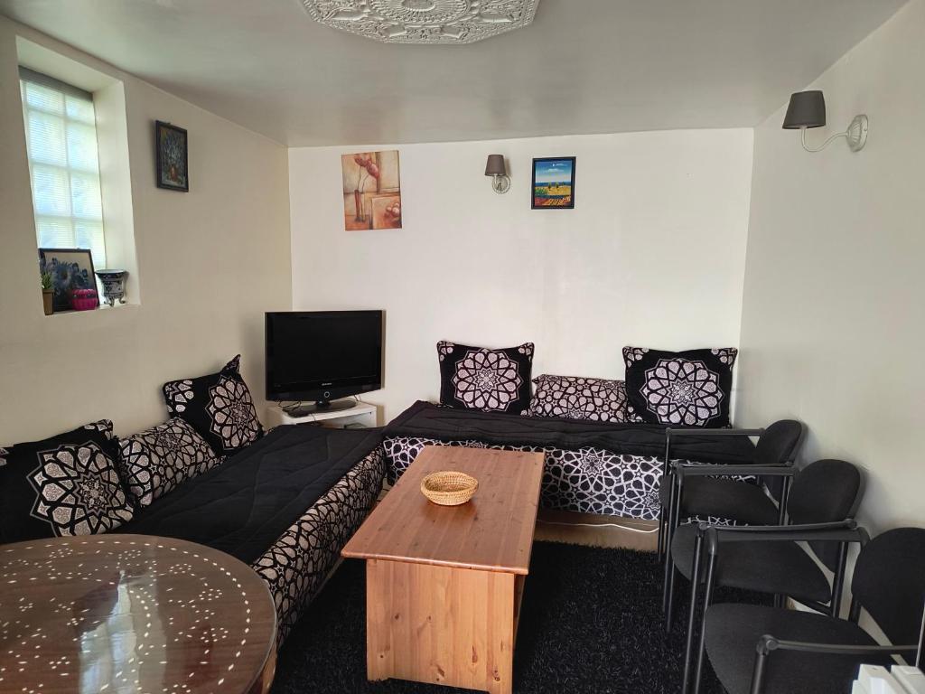 un salon avec un canapé et une table dans l'établissement Joli Appart indépendant dans le calme, à Épinay-sur-Seine