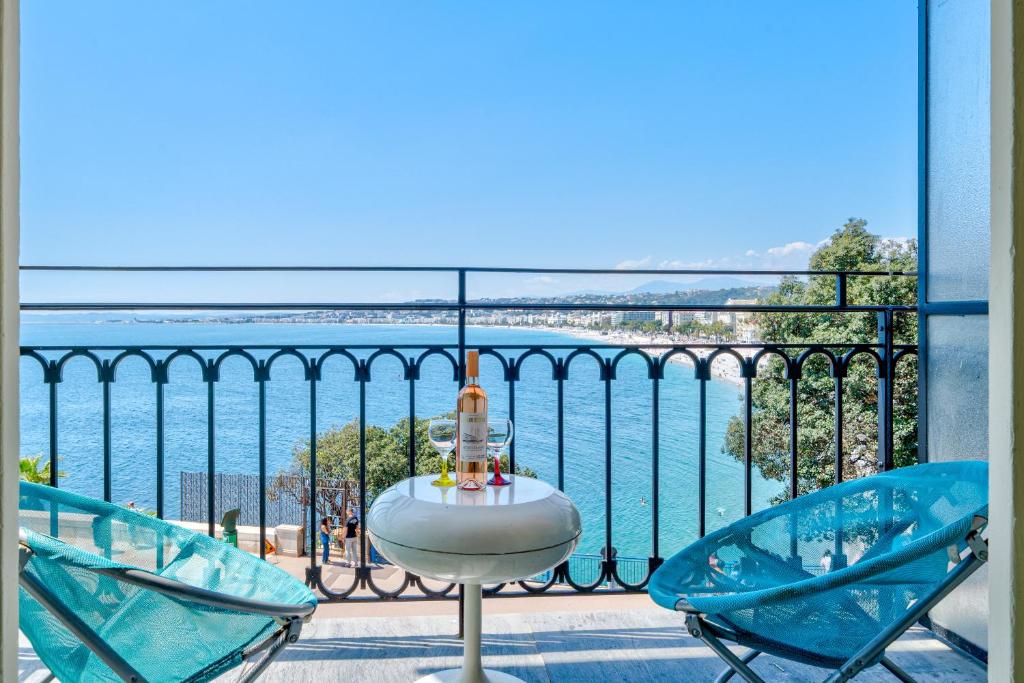 une table et des chaises sur un balcon avec vue sur l'eau dans l'établissement Panoramic Sea View - Promenade des Anglais, à Nice