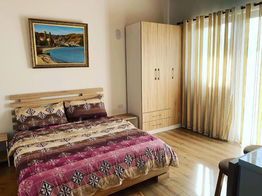 a bedroom with a bed and a large window at Pogradec Lake Apartments in Pogradec
