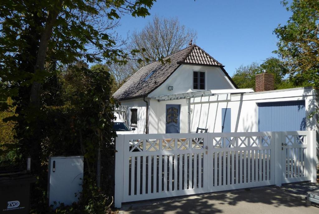 ein weißes Cottage mit einem weißen Zaun in der Unterkunft Sonnenschein 9184 - Neujellingsdorf in Neujellingsdorf