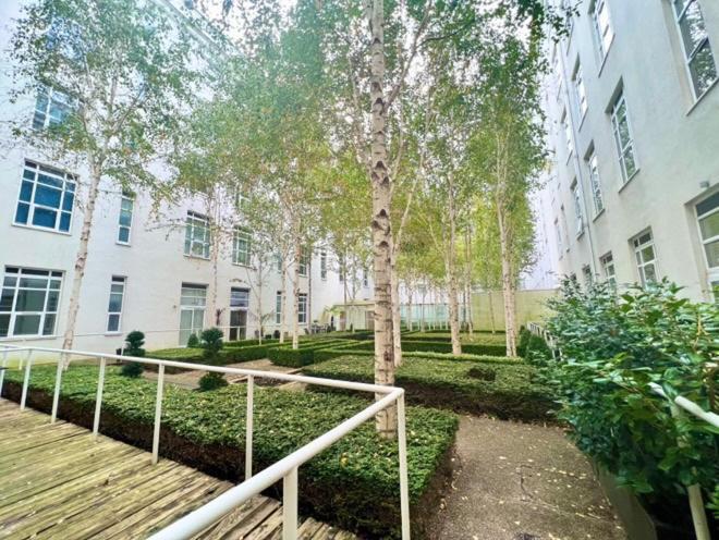 a staircase in front of a building with a tree at Luxury studio with super fast WiFi gated development in London