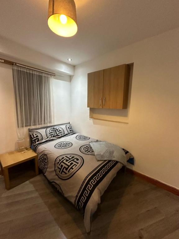 a bedroom with a bed and a lamp and a cabinet at Room 1 in south Yorkshire in Sheffield